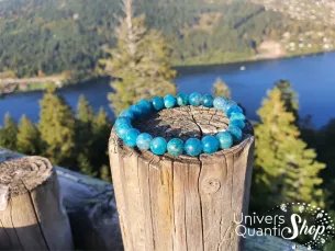 apatite bleue bienfaits en lithothérapie, bracelet apatite sur un tronc d'arbre dans la nature