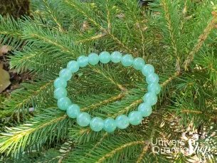 aventurine verte bracelet posé sur une branche de sapin en nature
