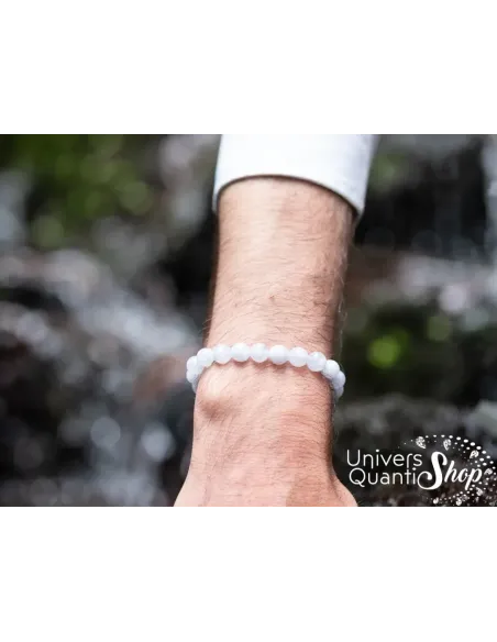 calcédoine pierre bleue bracelet lithothérapie porté sur un poignet d'homme devant une cascade