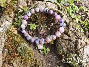 Charoïte bracelet 08mm posé sur un tronc d'arbre en forêt