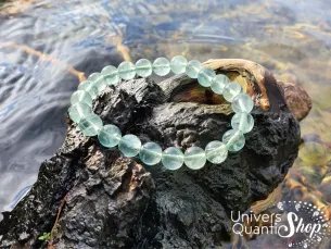 fluorite verte vertus, bracelet fluorine verte 08mm sur un bout d'arbre au bord d'un lac