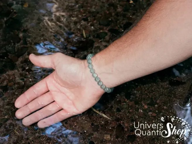 pierre fluorine verte bracelet 08mm porté sur un poignet d'homme avec la main tendue vers l'eau de source