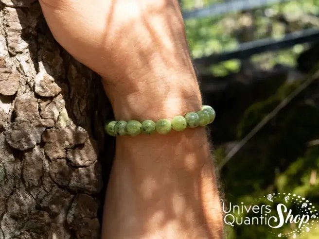 bracelet jade néphrite verte 08mm porté sur un poignet d'homme avec la main posée sur un tronc d'arbre
