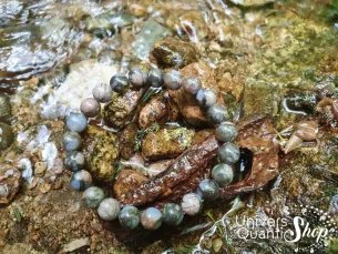 Libérite bleue vertus pierre de détente 08mm posé sur un rocher près d'une rivière