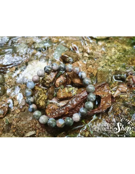 Libérite bleue vertus pierre de détente 08mm posé sur un rocher près d'une rivière