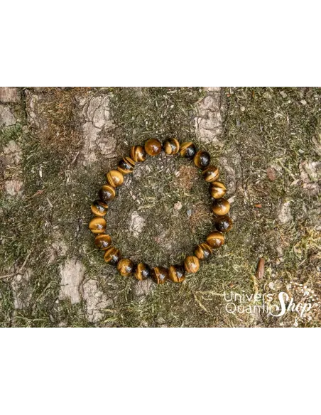 oeil de tigre vertus spirituelles, bracelet lithotherapie posé sur une écorce vue du dessus oeil de tigre vertus spirituelles, bracelet lithotherapie posé sur une écorce vue du dessus