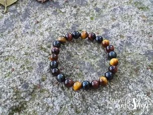 bracelet triple protection oeil de tigre, oeil de taureau, oeil de faucon 8mm sur un rocher