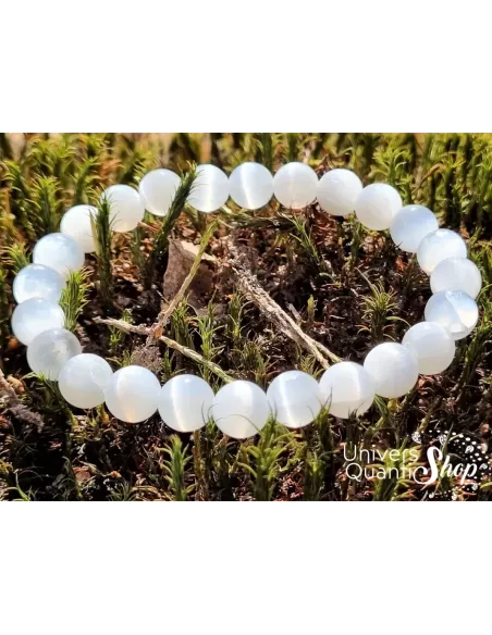 bracelet en sélénite de qualité extra AA 8mm posé sur une mousse dans la forêt vue zoom