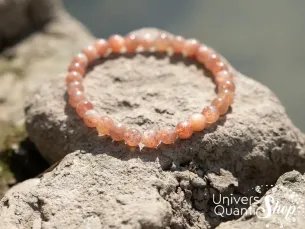 pierre soleil bracelet lithothérapie 6mm posé sur des rochers