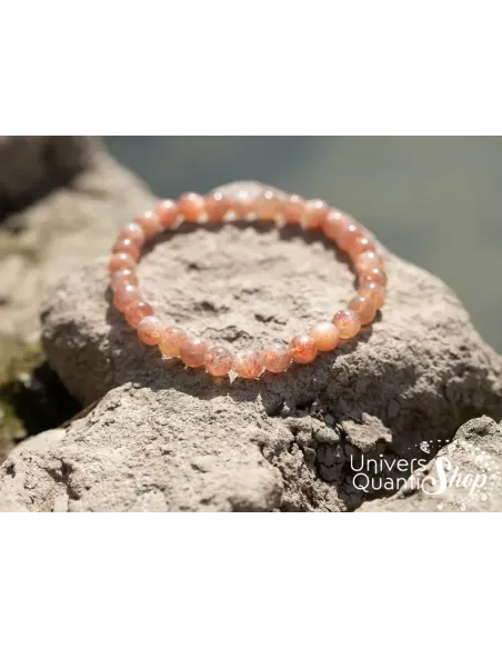 pierre soleil bracelet lithothérapie 6mm posé sur des rochers pierre soleil bracelet lithothérapie 6mm posé sur des rochers