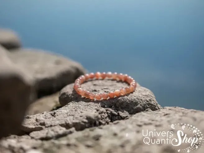 pierre du soleil vertus, pierre orange pour la joie de vivre bracelet 6mm sur un rocher