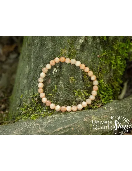 pierre de lune rose fertilité bracelet 6mm posé contre un arbre dans la forêt