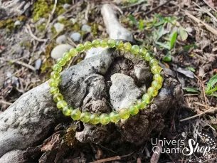 péridot bracelet pierre naturelle verte 06mm sur un morceau de bois en nature