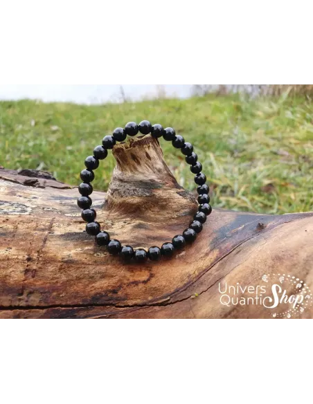bracelet onyx pierre noire naturelle 6mm posé sur un arbre
