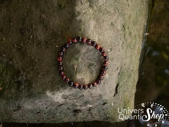 oeil de taureau vertus bracelet protection puissant 6mm posé sur un rocher avec une photo prise du dessus