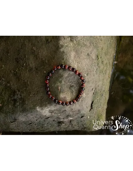 oeil de taureau vertus bracelet protection puissant 6mm posé sur un rocher avec une photo prise du dessus