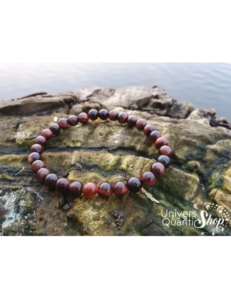 oeil de taureau bracelet pierre d'action 6mm posé sur un morceau de bois au bord de l'eau oeil de taureau bracelet pierre d'action 6mm posé sur un morceau de bois au bord de l'eau