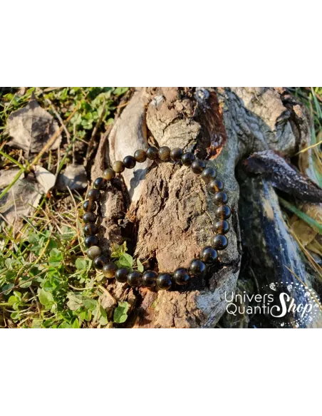 obsidienne dorée bracelet pierre naturelle dorée 6mm posé sur une racine d'arbre