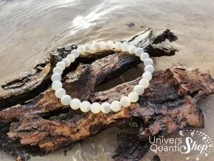 nacre bracelet pierre blanche naturelle 6mm sur un morceau d'arbre dans l'eau