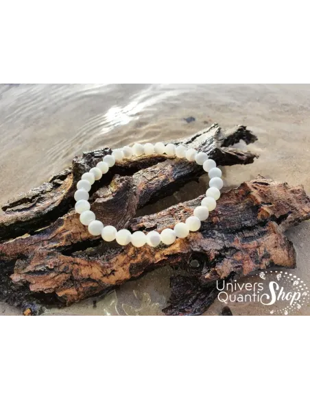 nacre bracelet pierre blanche naturelle 6mm sur un morceau d'arbre dans l'eau
