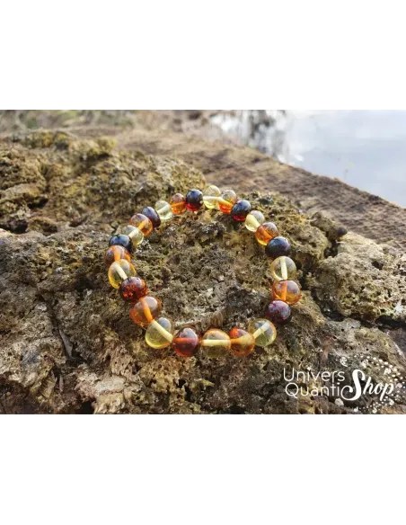 bracelet ambre véritable pierres roulées posé sur un morceau de bois