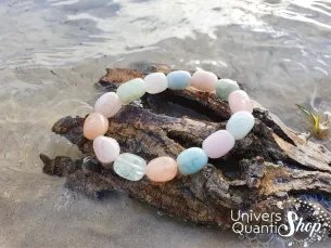 beryl prix bijou pierre naturelle roulée sur un morceau de bois au bord de l'eau