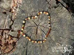 collier ambre bébé multicolore de baltique sur une souche d'arbre vue du haut