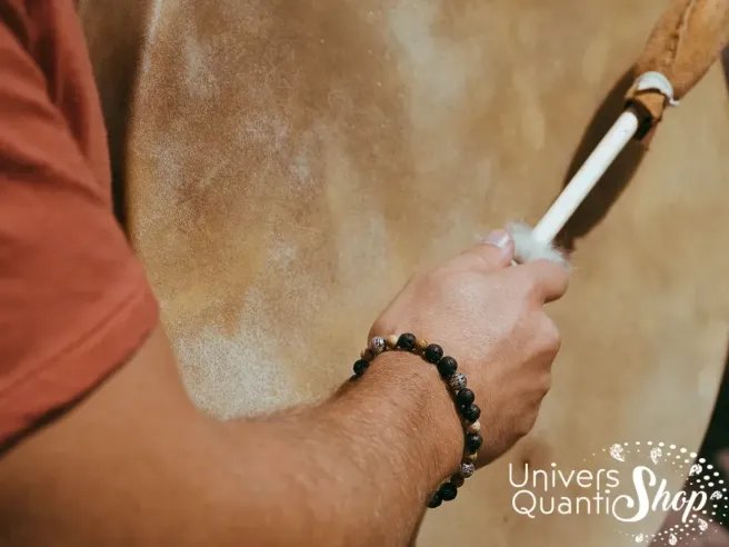 création bracelet pierre naturelle terre chamanique porté sur un poignet homme frappant un tambour chamanique