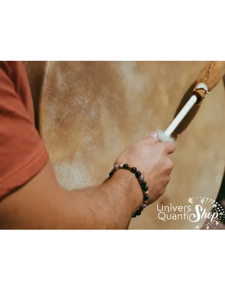 création bracelet pierre naturelle terre chamanique porté sur un poignet homme frappant un tambour chamanique création bracelet pierre naturelle terre chamanique porté sur un poignet homme frappant un tambour chamanique