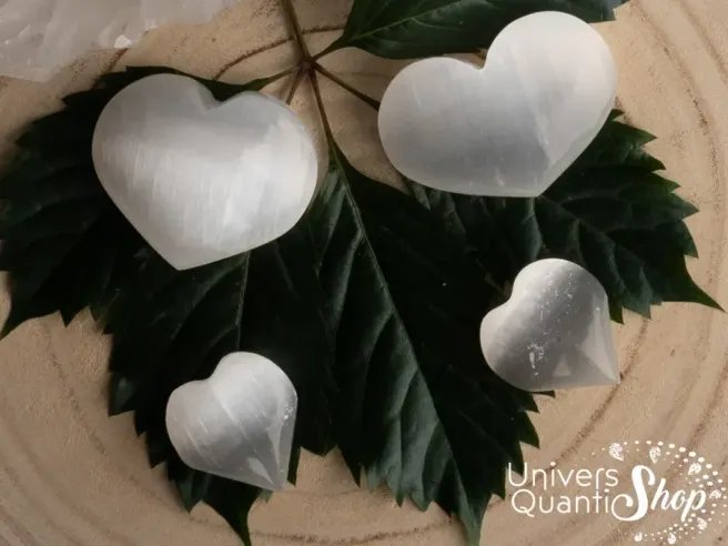 sélénite coeurs en pierres naturelles posés sur une feuille