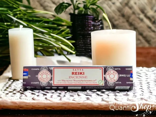 encens reiki satya, boite d'encens reiki posé sur un support avec des bougies en fond