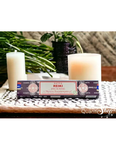 encens reiki satya, boite d'encens reiki posé sur un support avec des bougies en fond encens reiki satya, boite d'encens reiki posé sur un support avec des bougies en fond