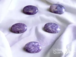 lépidolite, galet en pierre lépidolite violet qualité A+ posé sur un tissu blanc