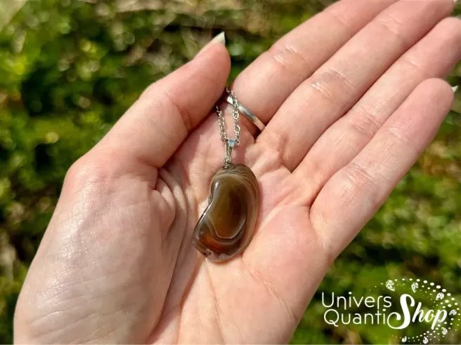 agate du botswana bienfaits, pendentif agate roulé posé dans une main