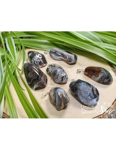 pendentif agate plume noire sur un rondin de bois, bienfaits et vertus en lithothérapie