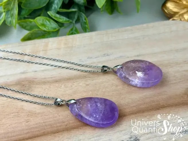 pendentif en pierre améthyste plate, pierre de sagesse et d'intuition posé sur une planche en bois