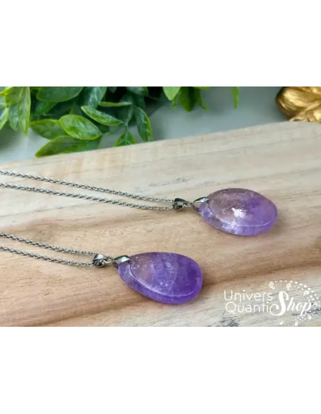 pendentif en pierre améthyste plate, pierre de sagesse et d'intuition posé sur une planche en bois