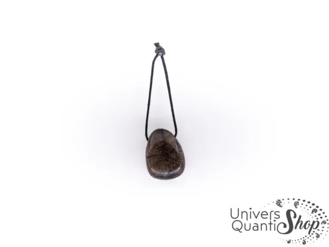 pierre chiastolite, pierre de croix pendentif en pierre percée sur fond blanc