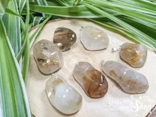 pendentif pierre quartz rutile roulée sur un rondin de bois