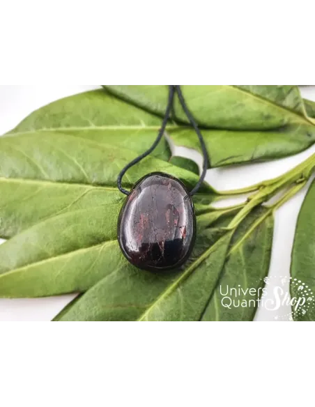 pierre grenat rouge - pendentif grenat rouge percé naturel posé sur des feuilles