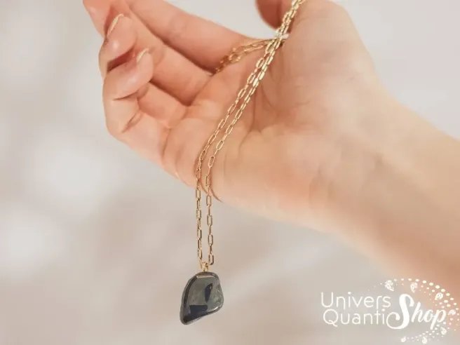 hématite pendentif pierre roulée naturelle dans une main - univers quantic shop