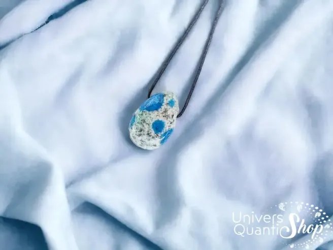 jaspe k2 signification - pendentif en pierre percée jaspe k2 sur du tissu bleu clair