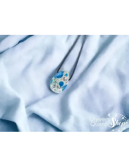 jaspe k2 signification - pendentif en pierre percée jaspe k2 sur du tissu bleu clair jaspe k2 signification - pendentif en pierre percée jaspe k2 sur du tissu bleu clair