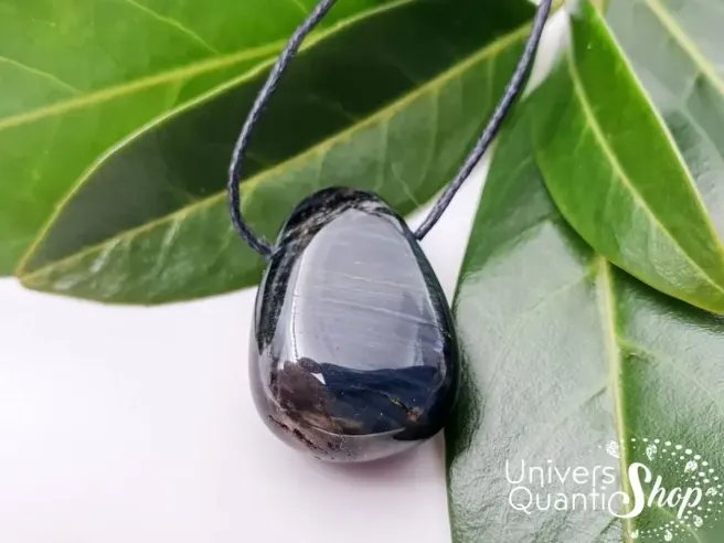 pendentif pierre oeil de faucon - pierre percée oeil de faucon naturelle sur des feuilles vertes