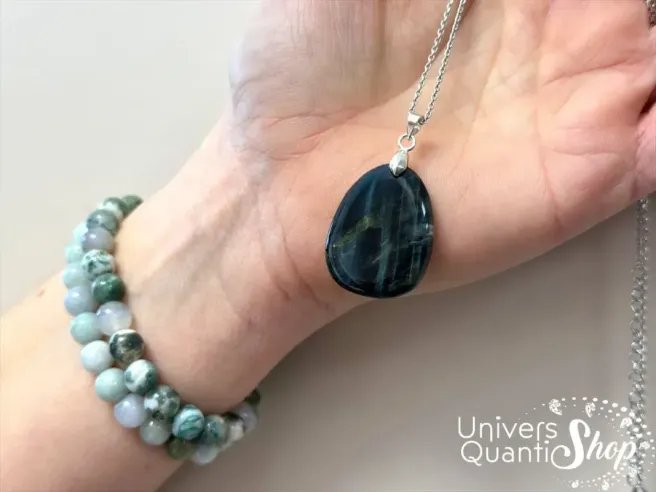 oeil de faucon lithothérapie, pierre naturelle en pendentif pierre plate dans une main