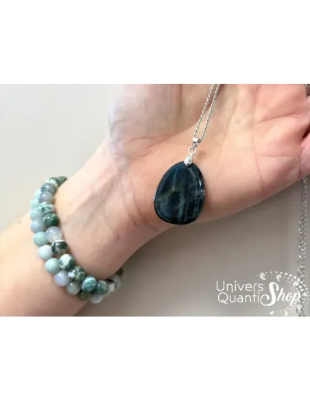 oeil de faucon lithothérapie, pierre naturelle en pendentif pierre plate dans une main oeil de faucon lithothérapie, pierre naturelle en pendentif pierre plate dans une main