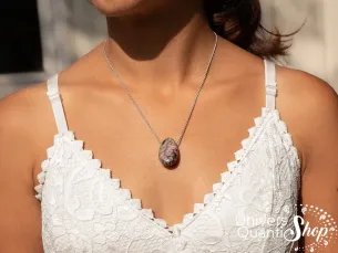 rhodonite pierre, pendentif en pierre percée naturelle rose porté sur une femme