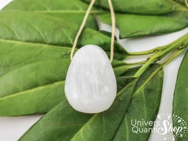 pendentif sélénite naturelle qualité A sur des feuilles, vertus & propriétés de la sélénite en lithothérapie