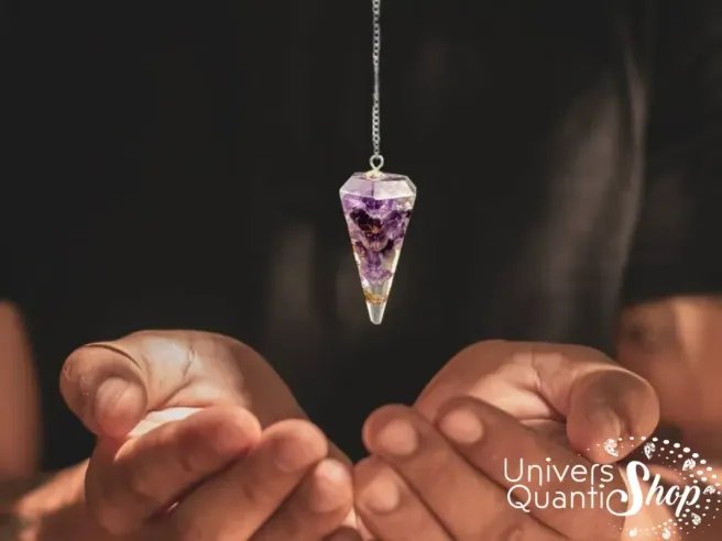 pendule divinatoire améthyste orgonite en pointe suspendu au dessus des mains