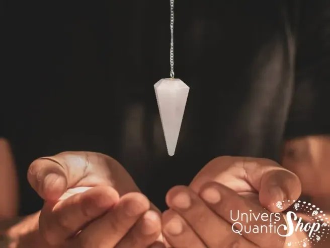 pendule divinatoire quartz rose facettée suspendu au dessus des mains - pierre de l'amour - outil de radiesthésie